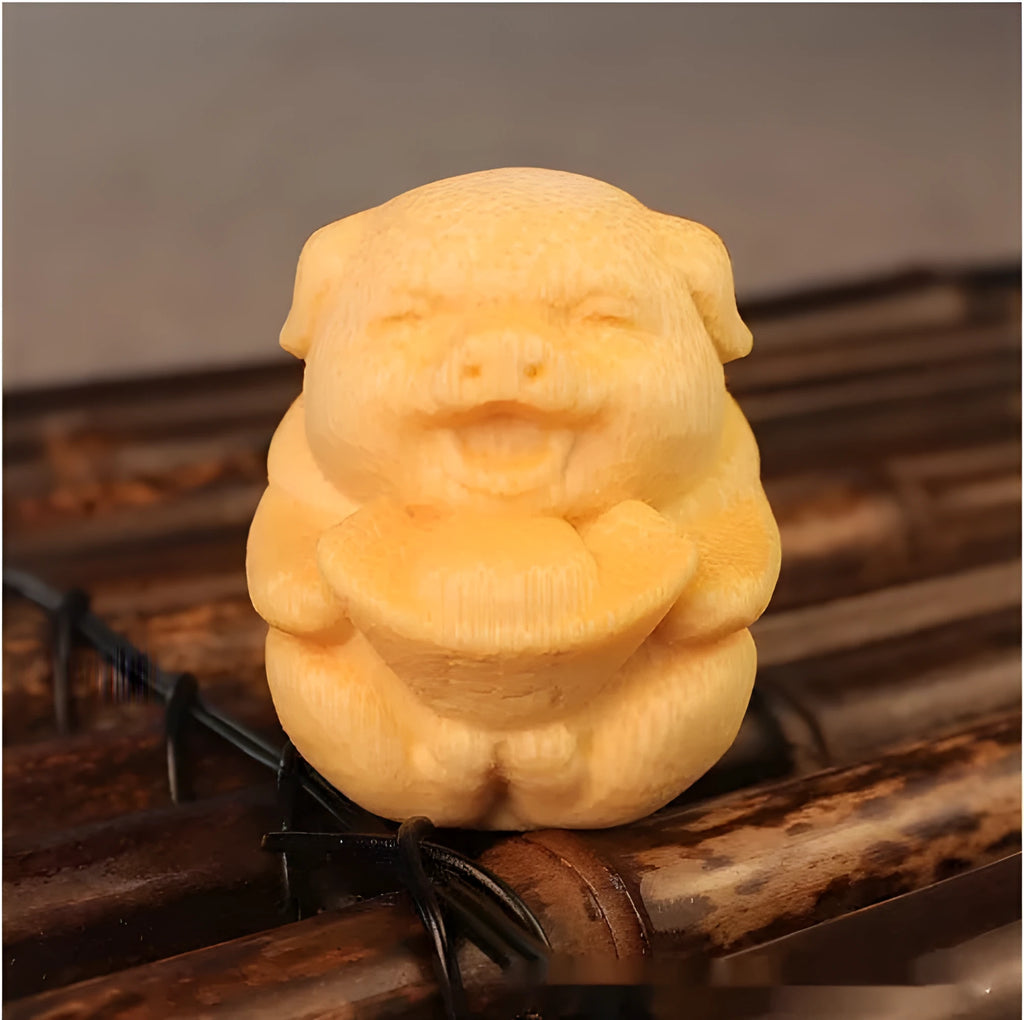 Small cute Fulu Pig bamboo carving ornament on a surface, showing its ingot shape.