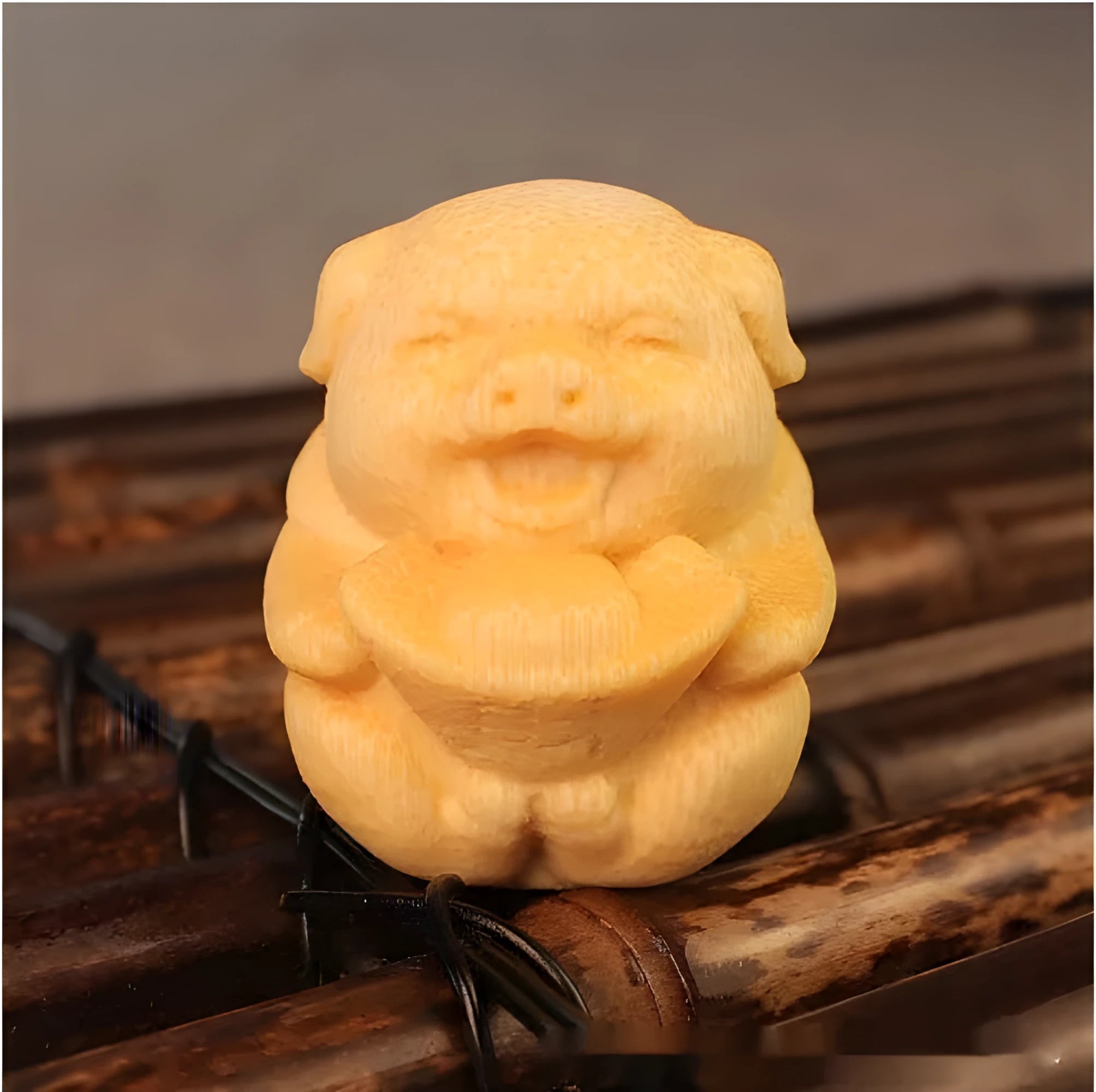 Small cute Fulu Pig bamboo carving ornament on a surface, showing its ingot shape.