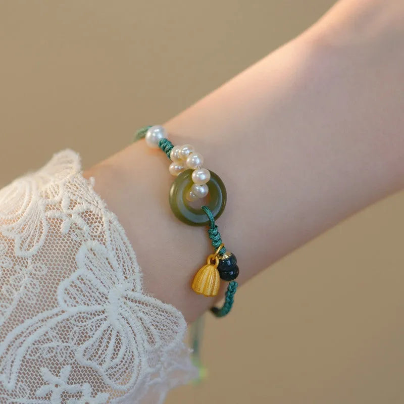 Hand-woven women's watch band with a pearl peace buckle closure on a flexible wire bracelet.