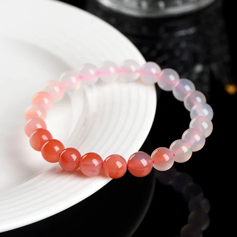 A gradient coloured Yanyuan agate bracelet with polished geometry-shaped beads on a white background.