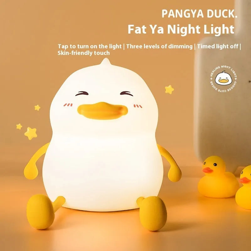 Chubby silicone desk night lamp with integrated mobile phone holder showing soft glowing light.