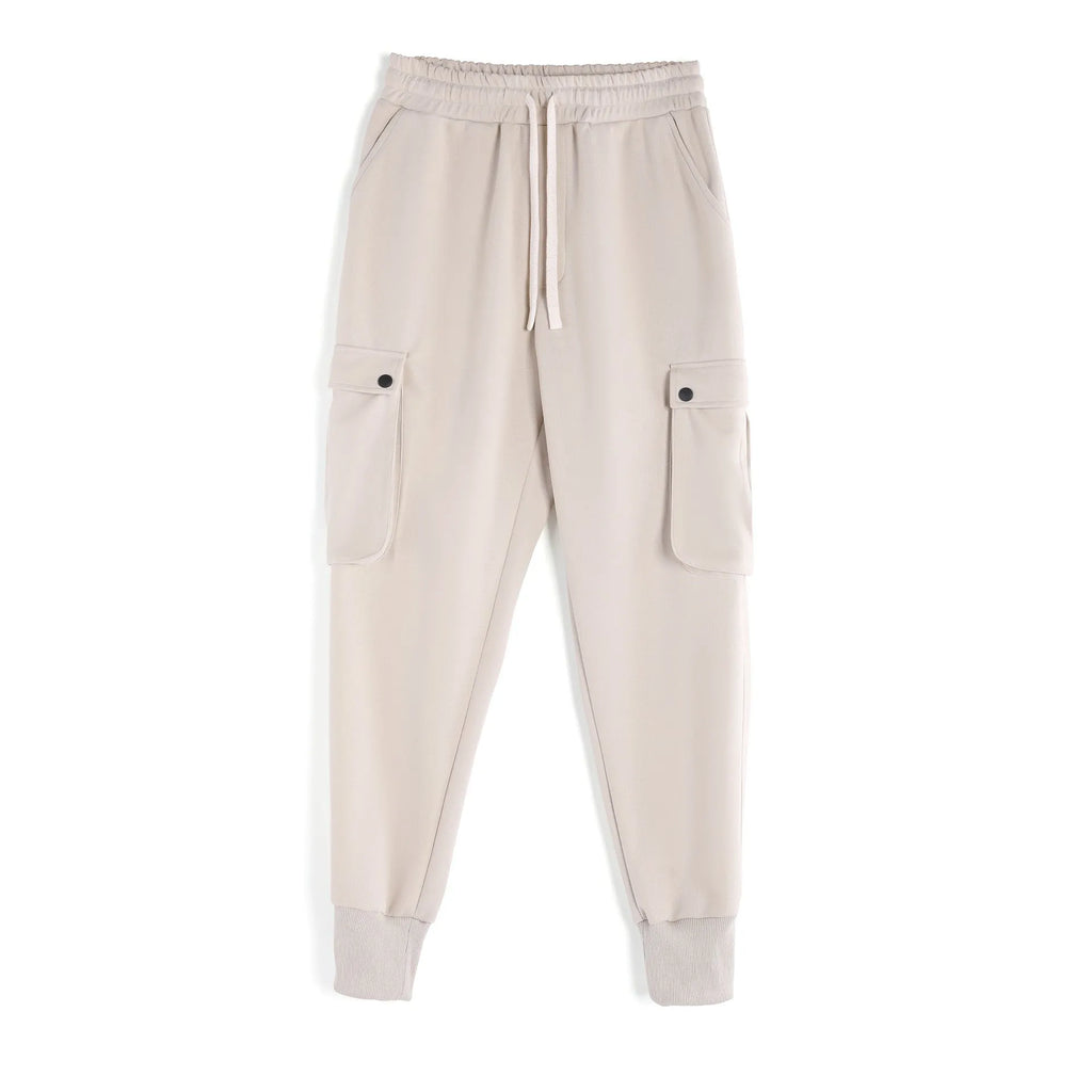Men's loose grey cotton sports trousers with ankle ties and side pockets laid flat.