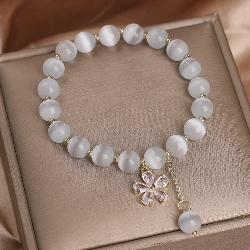 White cat's eye stone bracelet with flower tassel detail and morganite safety buckle pendant