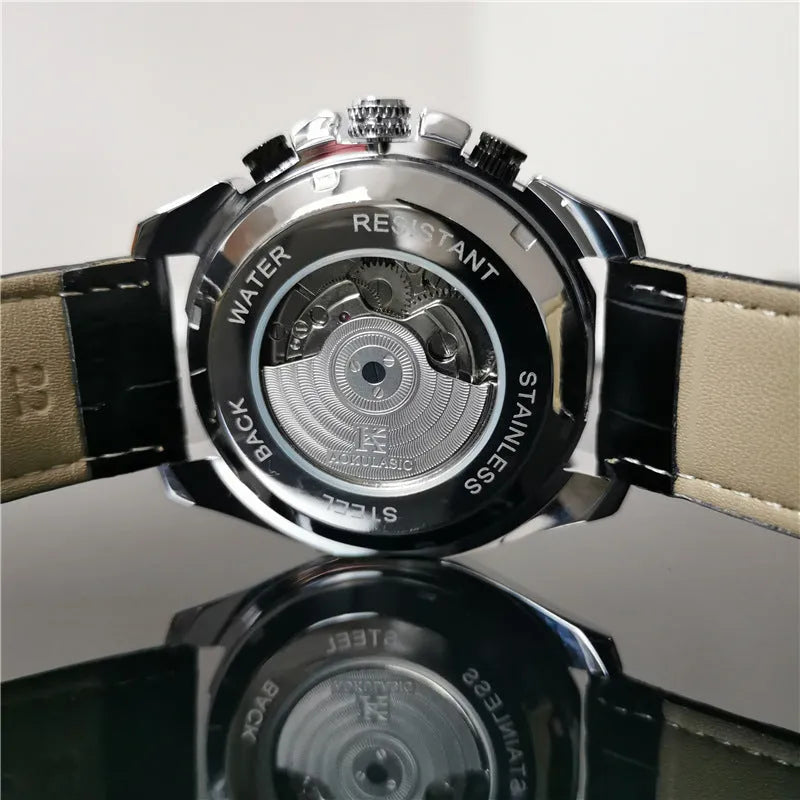 Men's automatic mechanical watch on wrist showing silver metal case and black dial.