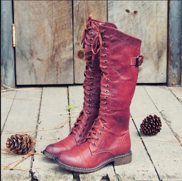 Women's black synthetic PU knight boots with a cross-strap design on the upper.