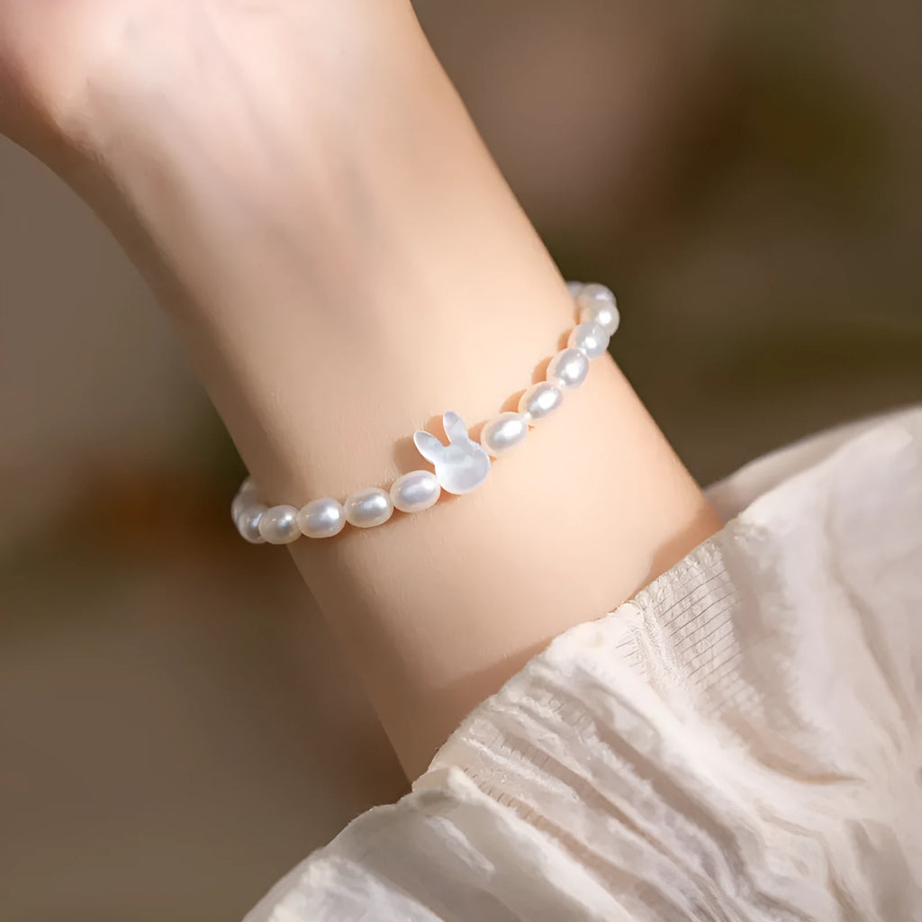 White shell bead bracelet with silver rabbit charm on elastic string
