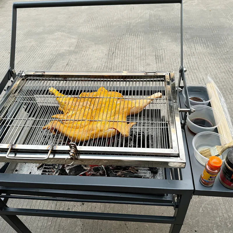 Large foldable charcoal barbecue oven set up in a garden for grilling.