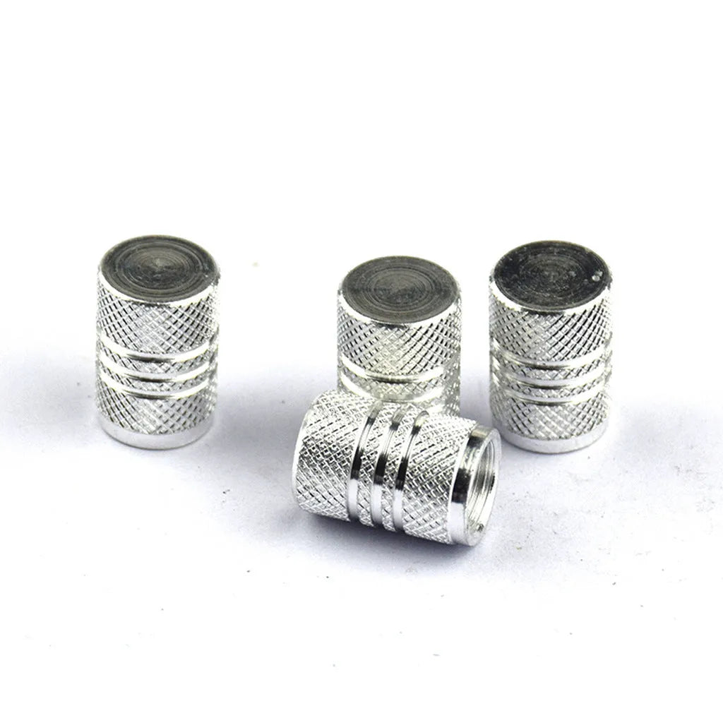 Set of coloured aluminium alloy car tyre valve caps showing stainless steel threads, displayed on a grey background.