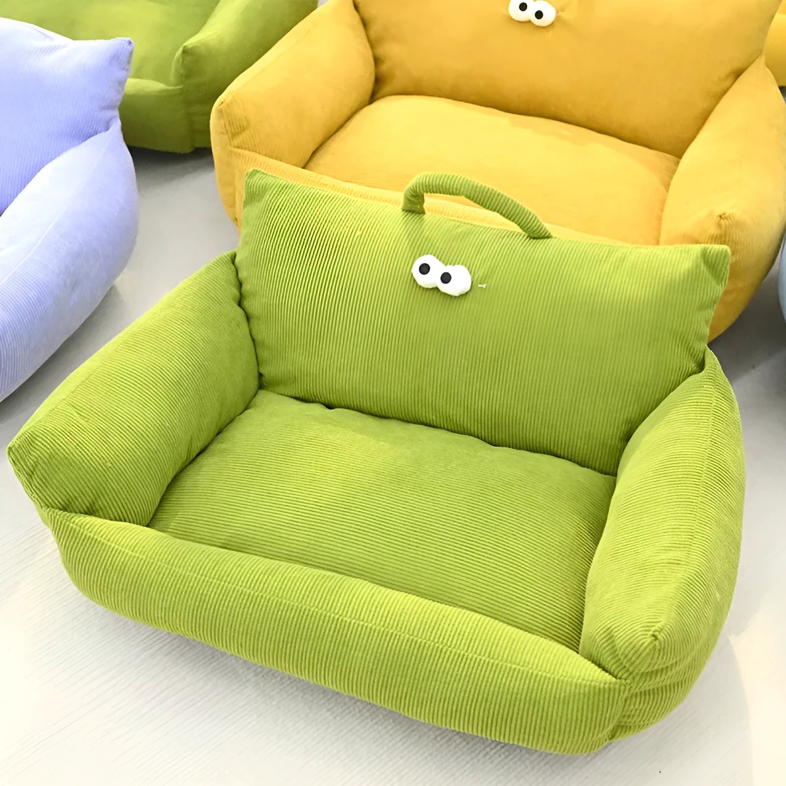 Cartoon big eye pet sofa kennel bed in blue, showing plush Moon velvet material and large adhesive eyes.