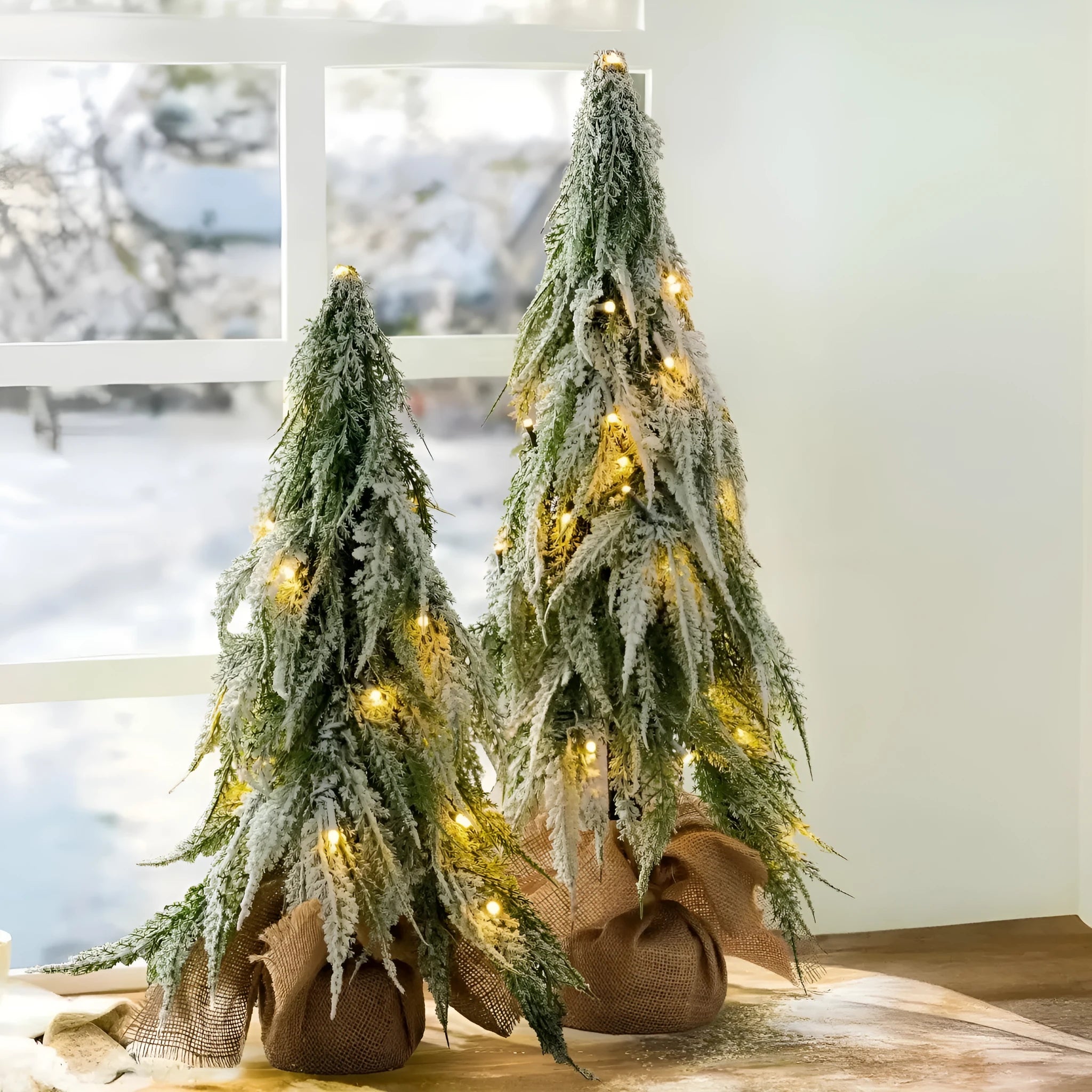 Small 24-inch white snow spray Christmas tree with integrated lights on desktop