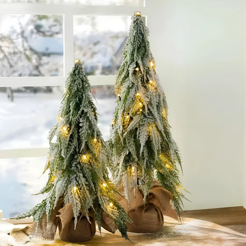 Small 24-inch white snow spray Christmas tree with integrated lights on desktop