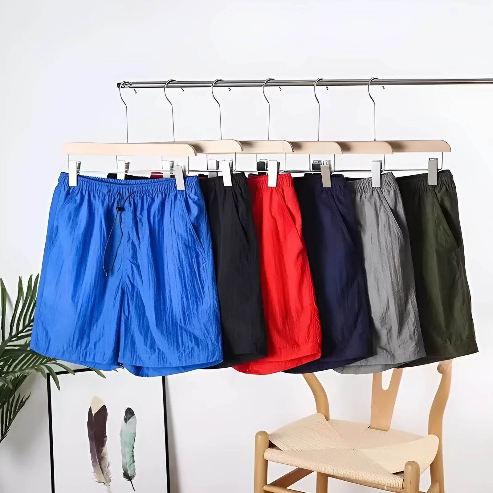 Man wearing straight-cut quick-dry sports shorts in grey, showing the thin polyester fabric and casual fit.