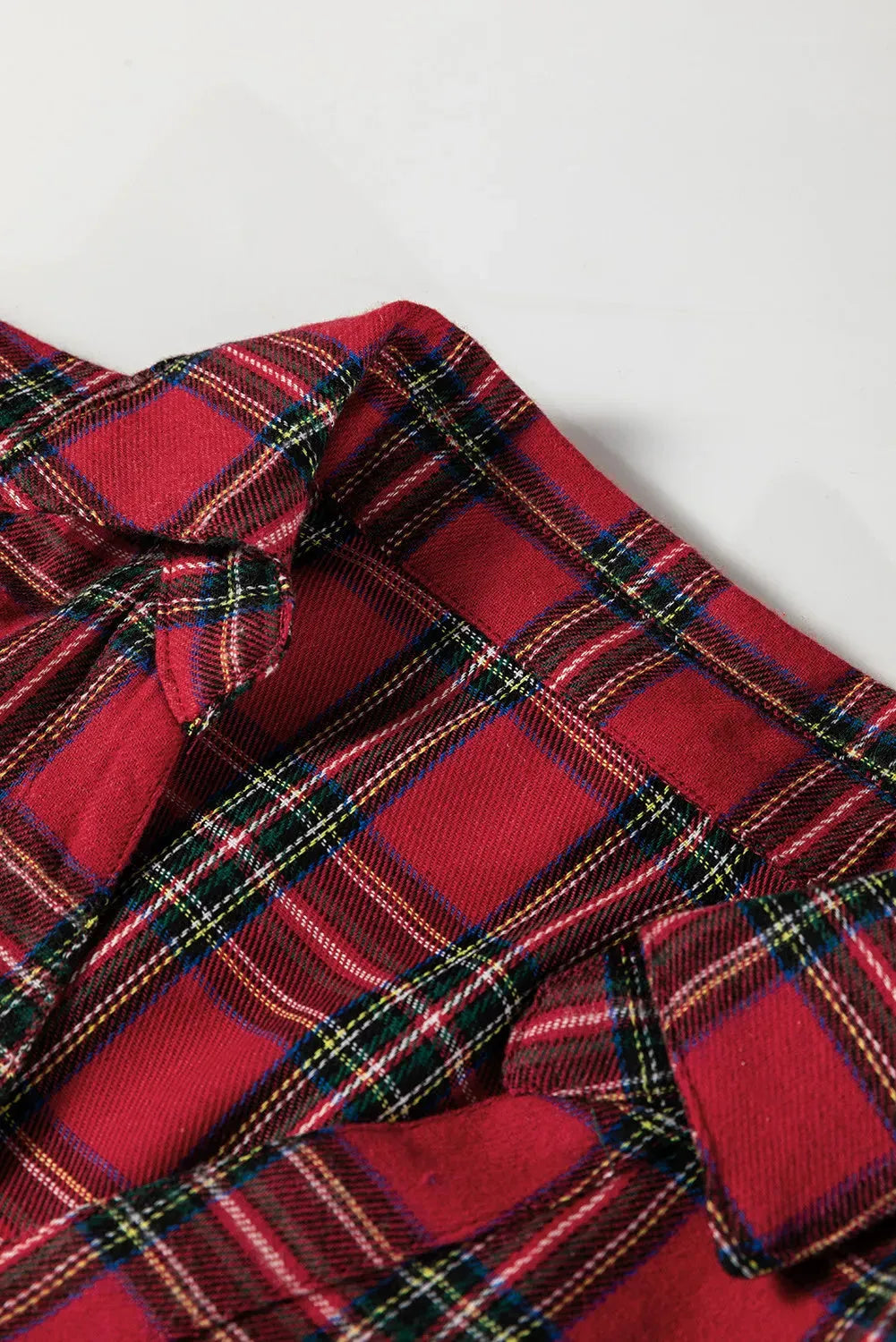 Red and white plaid women's mini dress with a shirt collar, half-button front, long sleeves, and a ruffle hem.