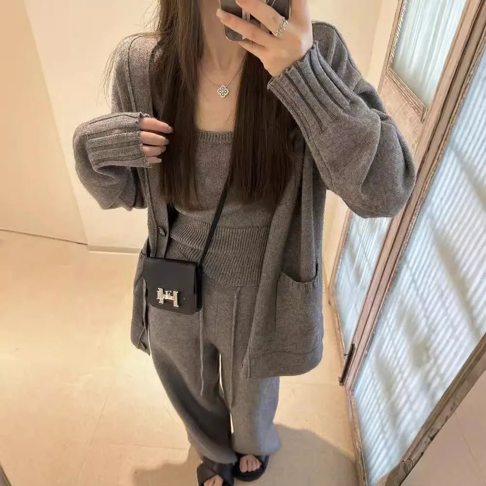 Women's light brown knit cardigan vest and trousers three-piece set laid flat.