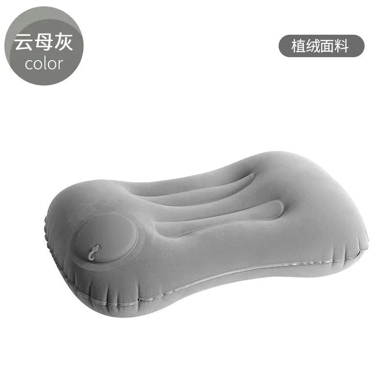 Grey flocking inflatable travel pillow showing compact rectangular shape and textured surface.
