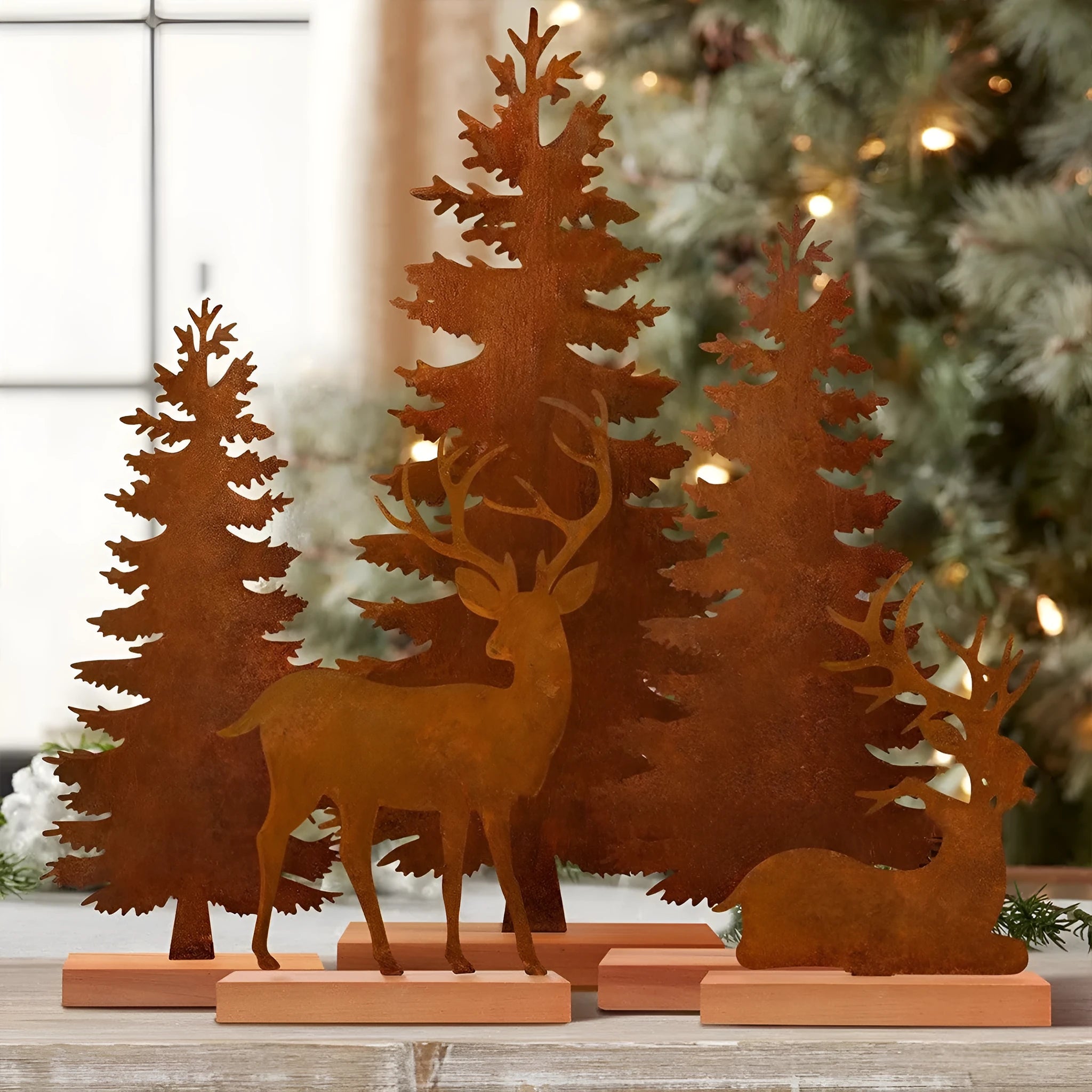 Three rusty metal Christmas ornaments featuring elk and tree silhouettes on a white background