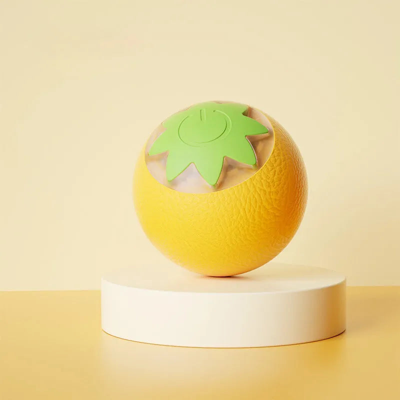 Small green automatic rolling ball toy for dogs and cats on a wooden floor.