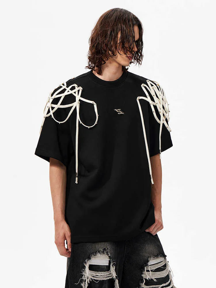 Black loose fit short-sleeve T-shirt with padded shoulders and decorative rivet ribbon detail on a hanger.