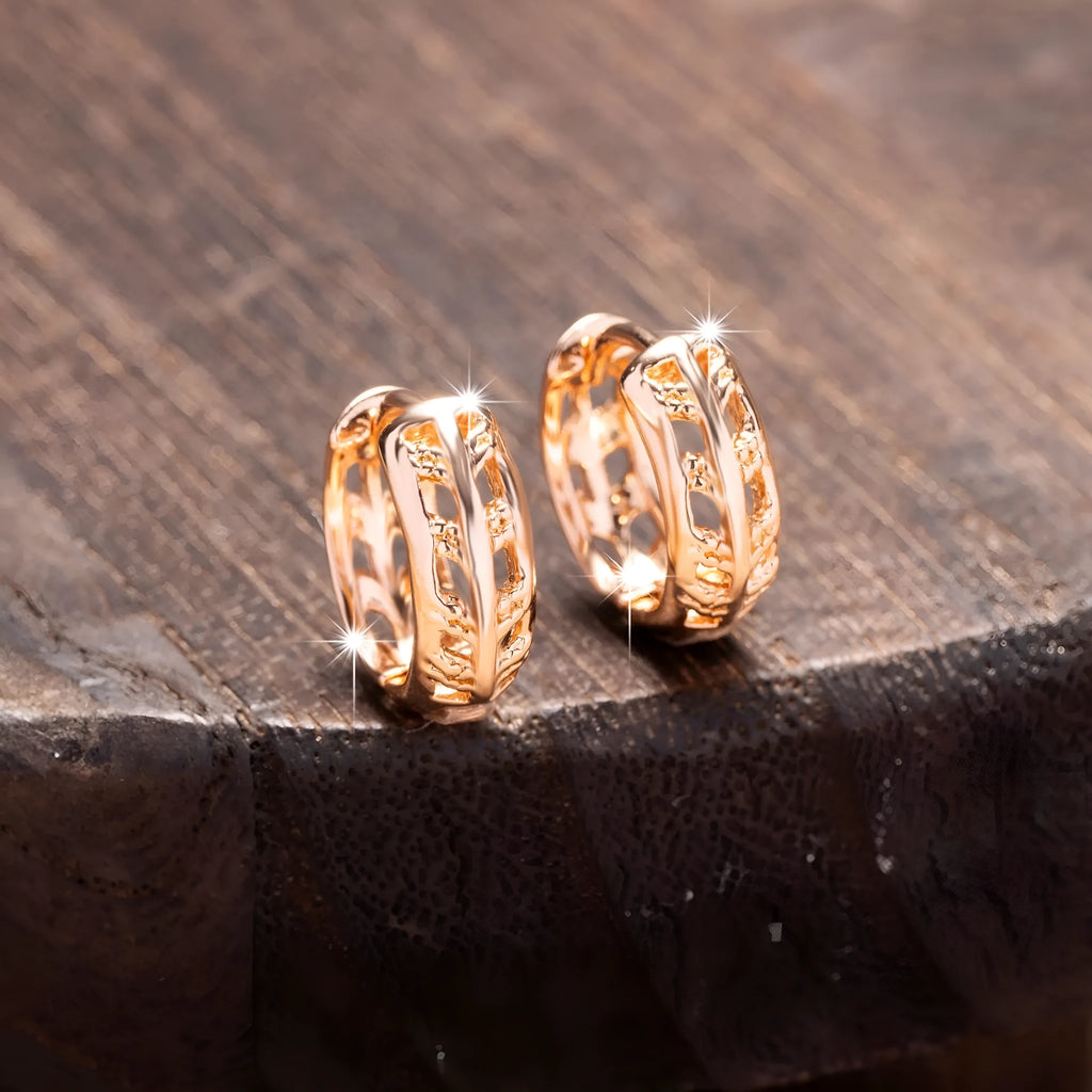 Small copper earrings with a hollow leaf and heart design in a rose gold finish.