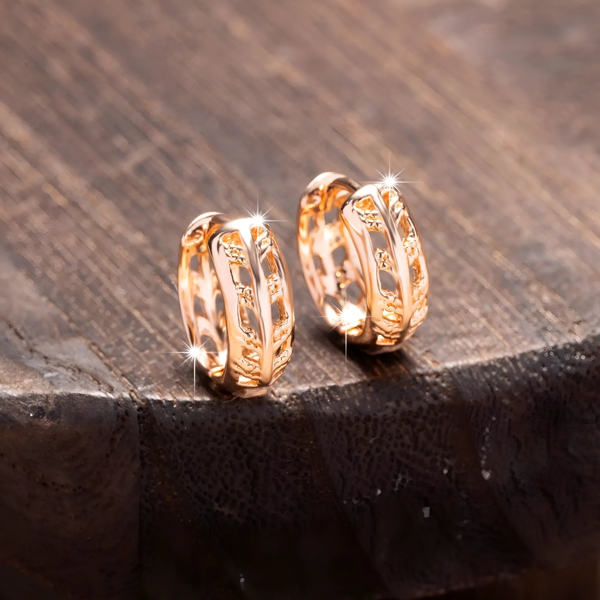 Small copper earrings with a hollow leaf and heart design in a rose gold finish.