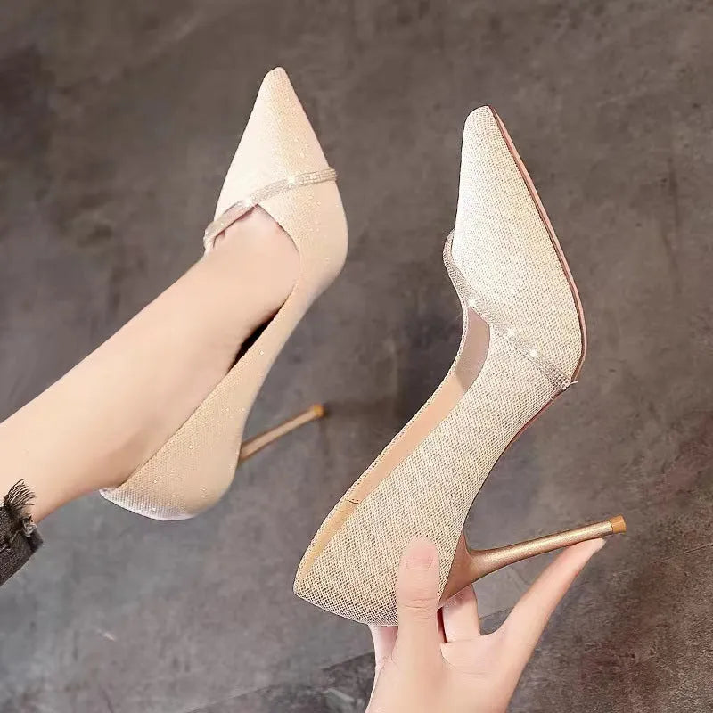 Gold and black women's stiletto pointed toe high heels on a white background.