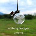 Glass car perfume pendant with preserved flowers inside, shown in light pink hydrangea colour
