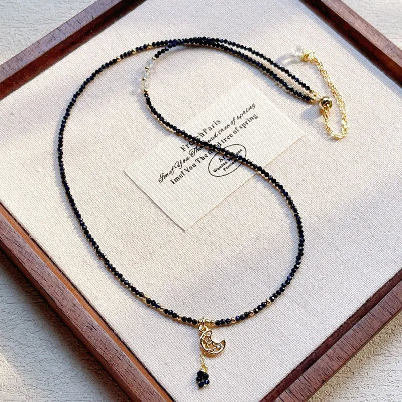 Close-up of a women's multi-layer bracelet with three blue gold sand stone rings on a wrist.