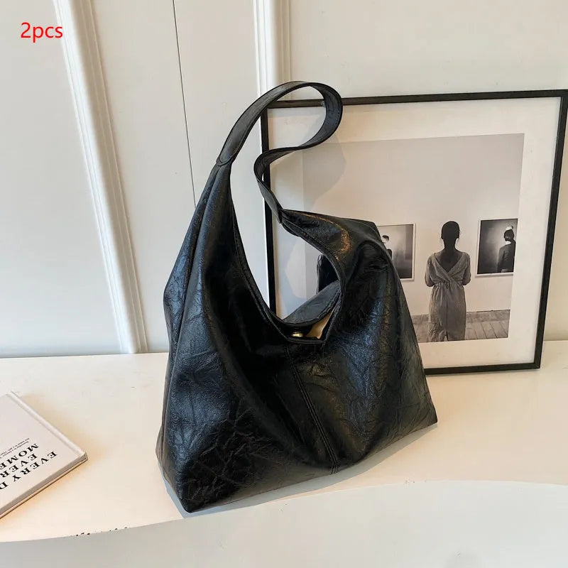 Casual soft PU leather shoulder bag in black with visible stitching and a front sandwich pocket.