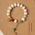 Close-up of a hand-woven white jade Bodhi bracelet with pumpkin and lotus beads on an adjustable rope.