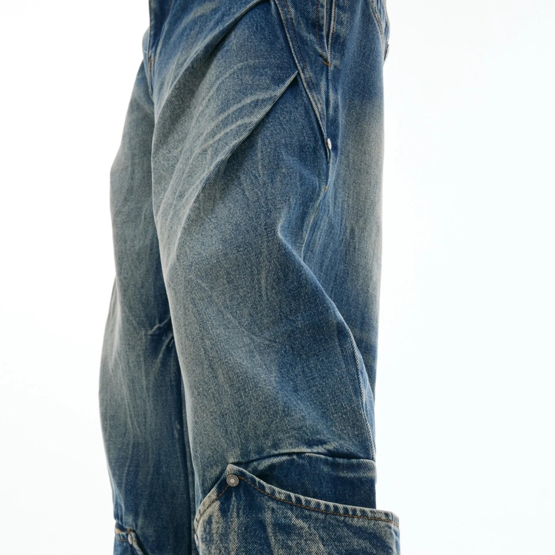 Men's verdant blue jeans with a retro washed burst pattern and curved knife details, shown in a loose fit.