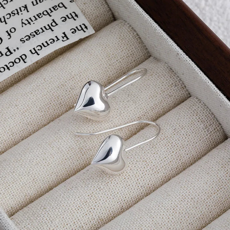 Silver-coloured heart-shaped earrings with three-dimensional glossy design and Korean-style aesthetic