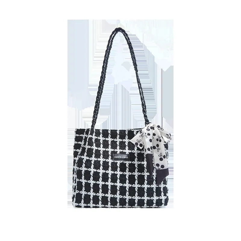 A black woven wool horizontal square shoulder bag showing external sandwich pocket and internal organiser compartments.