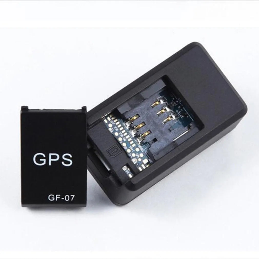 Small black plastic magnetic GPS car tracker device with USB cable.