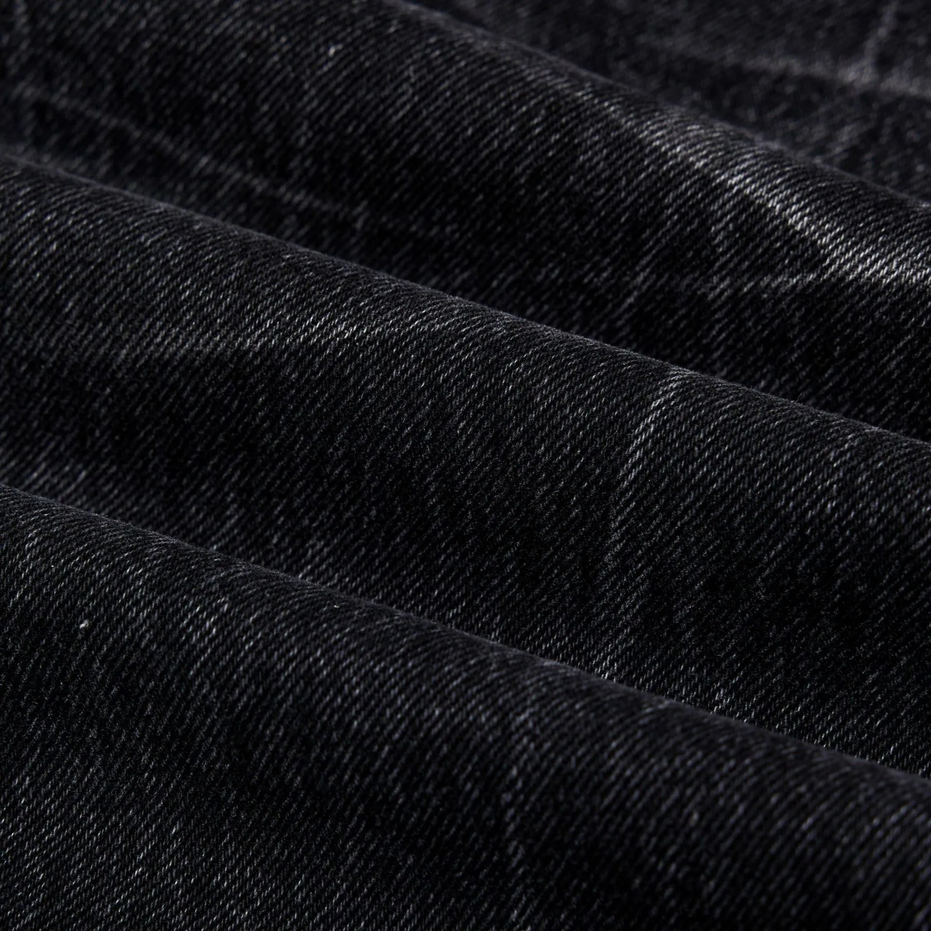 Black men's straight-leg jeans showing a cracked, washed denim finish on a plain background.
