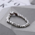 Handmade women's bracelet with irregular silver squares on wooden beads and elastic band