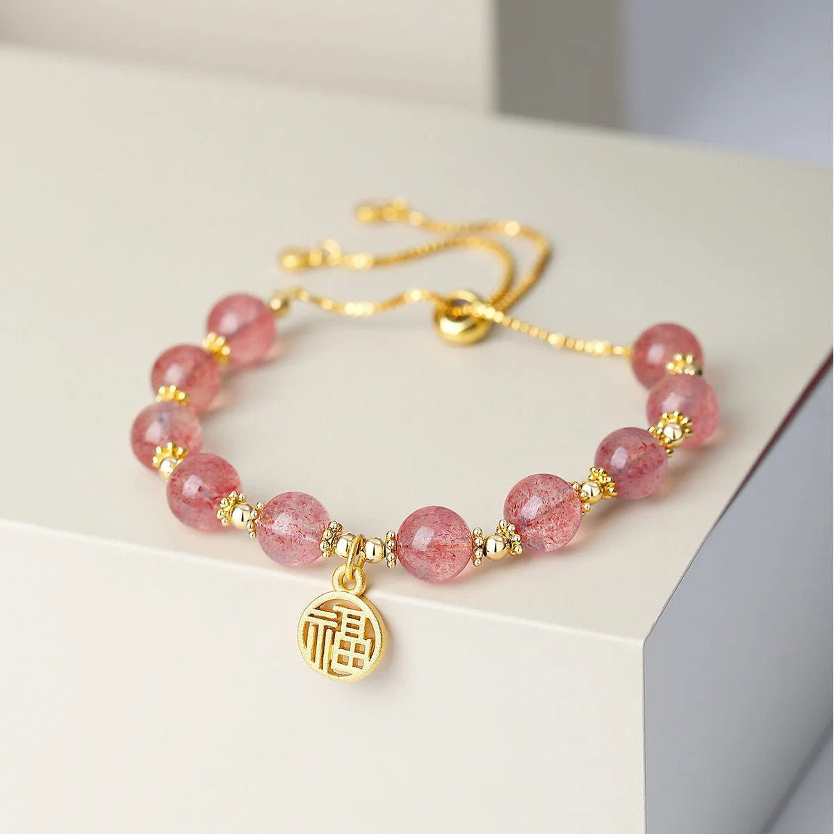 Women's strawberry quartz crystal bracelet with geometric design and fu character element