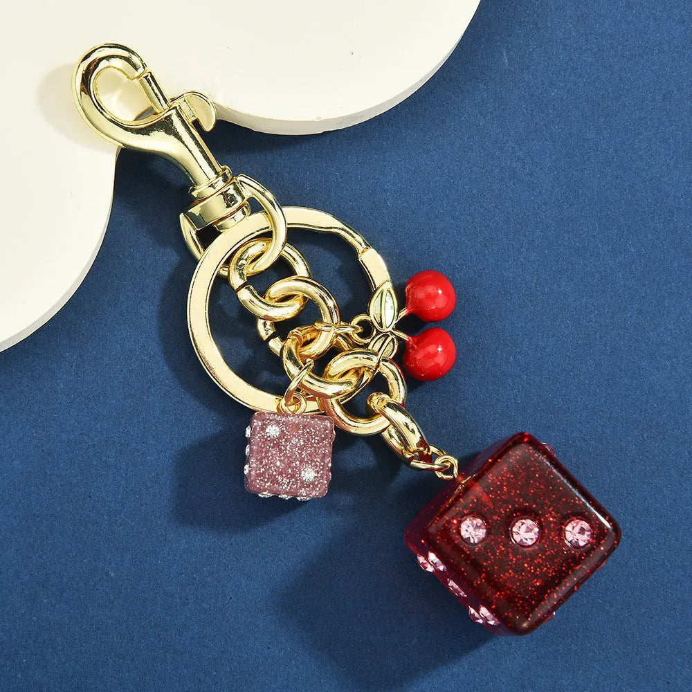 Square metal keychain pendant featuring a vintage cherry red and white two-tone dice pattern.