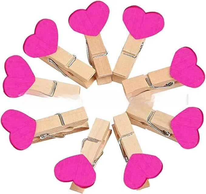 Five handmade solid wood heart-shaped hair clips in red, white, and pink on a wooden surface.