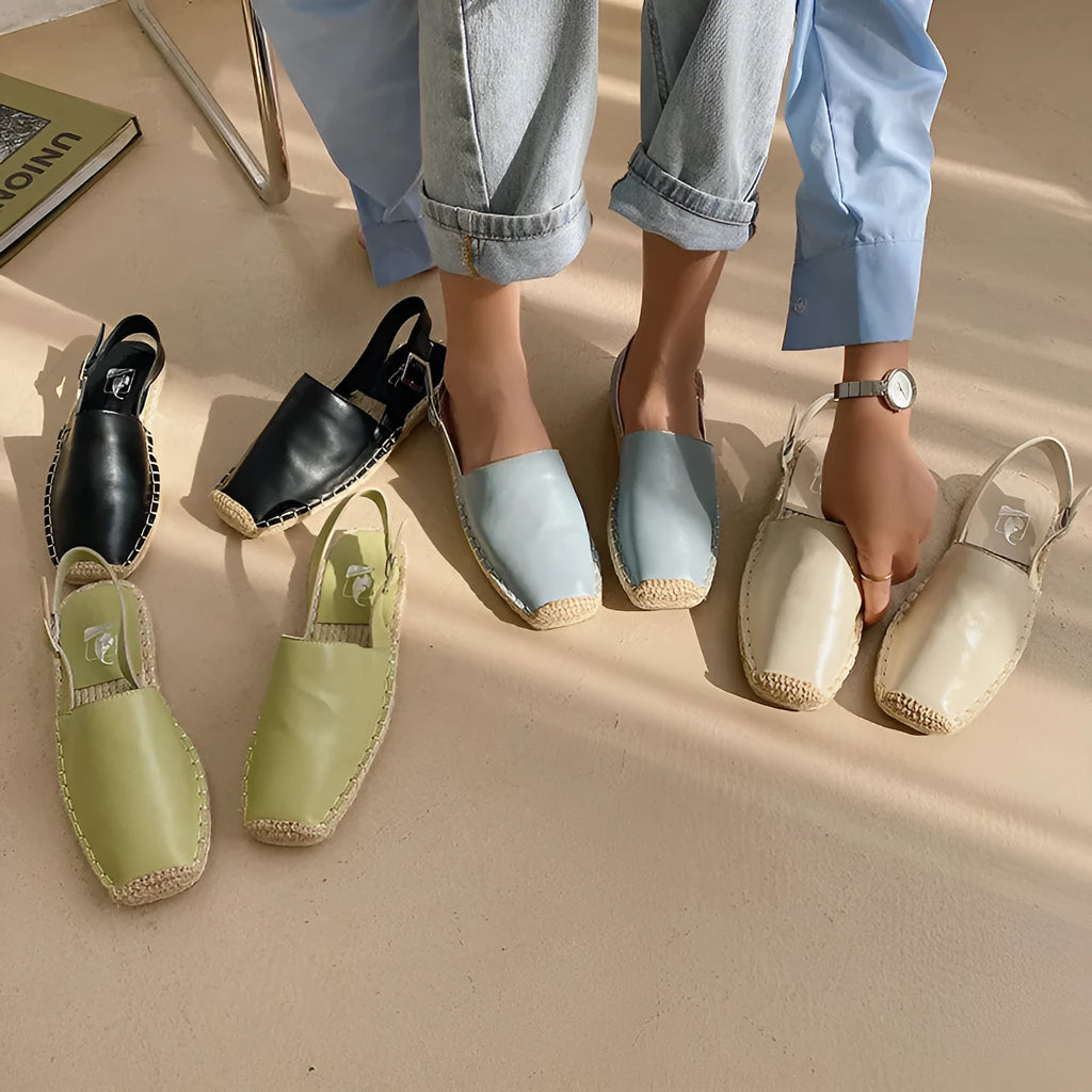 Women's beige canvas flat sandals with animal pattern, showing flat sole and fisherman shoe design.