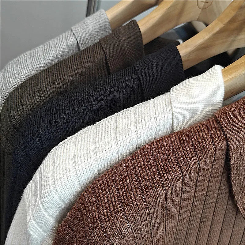 Man wearing a loose grey striped knit sweater with a lapel, long sleeves, and textured fabric.