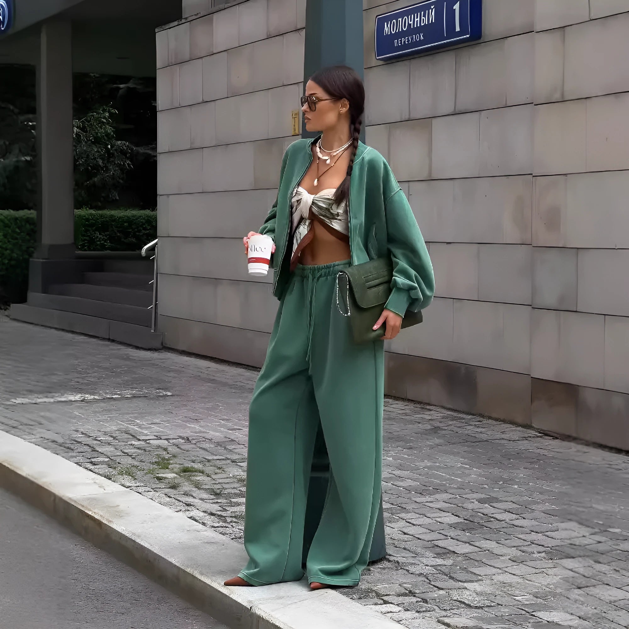 Women's green thermal sweater with front zip and stand collar, paired with matching trousers, on a white background