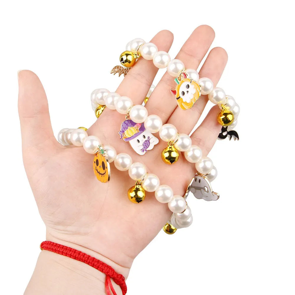 Simulated pearl Halloween cat collar with a choice of purple ghost, skull, or smiling pumpkin charm.