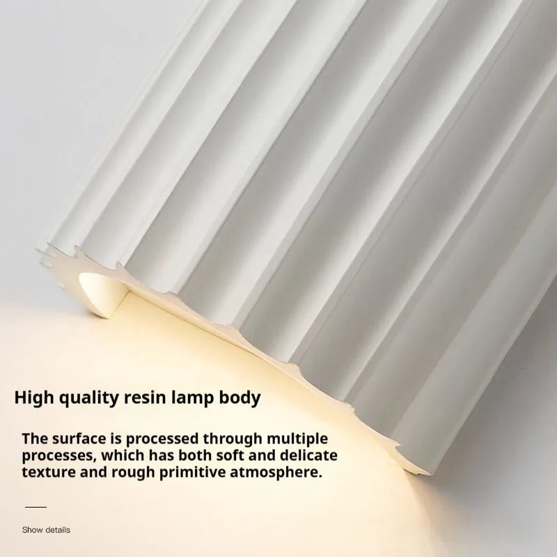 Nordic style wall light with a white macaron shell-shaped shade mounted on a hallway wall.