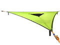 Black polyester portable multi-person triangle hammock lying on grass with trees in background