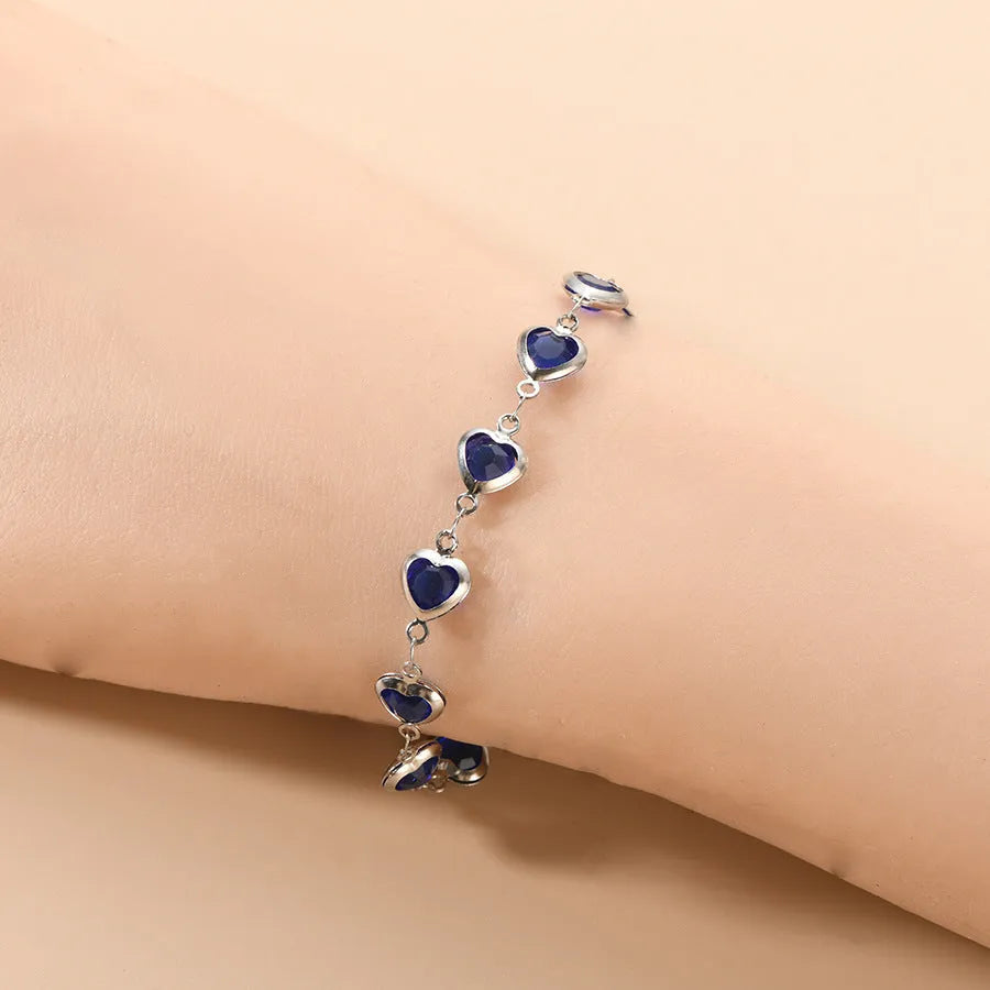 Stainless steel Devil's Eye geometric heart bracelet in red, blue, or green on a white background.