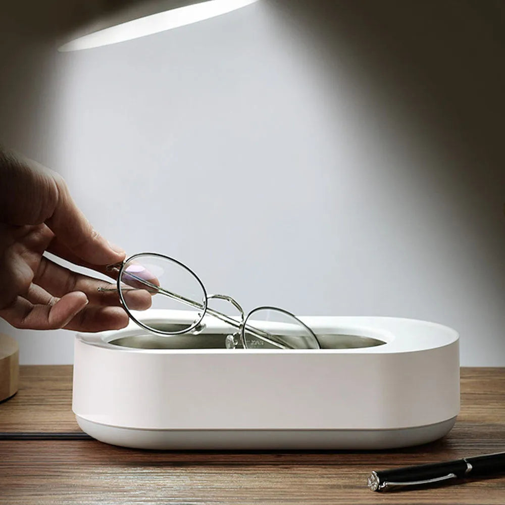 White portable ultrasonic cleaner with stainless steel tank and touch button.