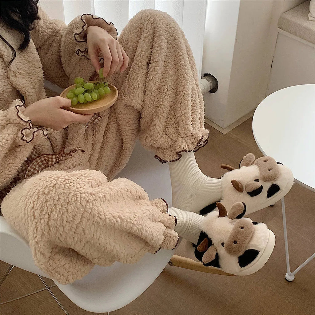 White cow print faux fur slippers for women with a non-slip textured sole.
