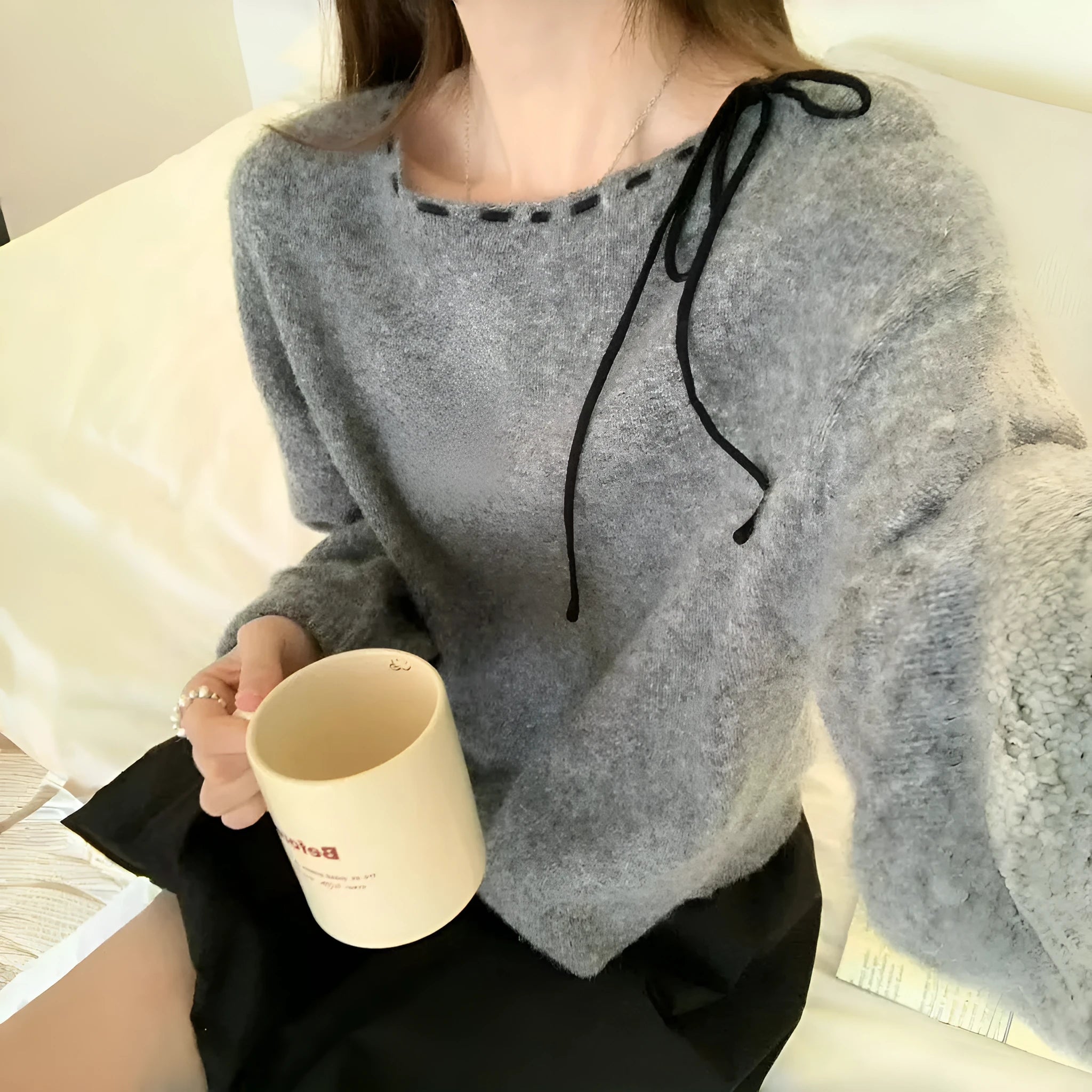 Women's loose-fitting black and grey knitwear pullover sweater on a hanger