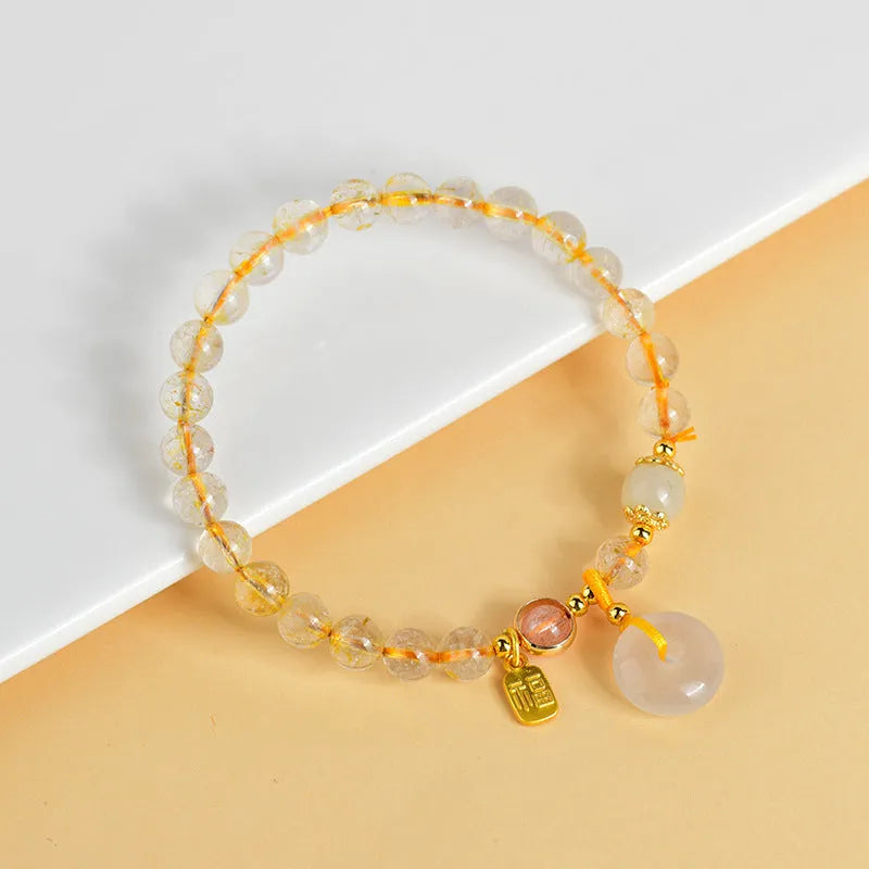 Gold rutilated quartz crystal bracelet with safety buckle closure and geometric pendant
