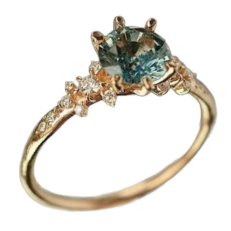 Gold plated geometric ring with a claw-set zircon stone and a textured square pattern on the band.